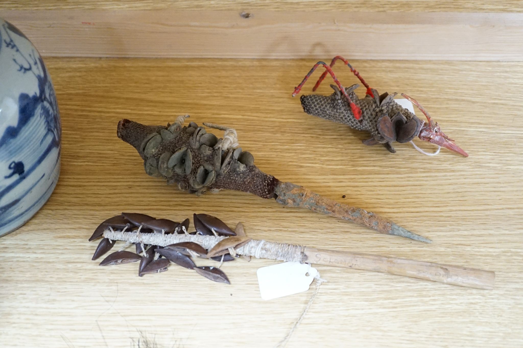 Two Japanese carved wood masks, an African beaded mask and three similar rattles